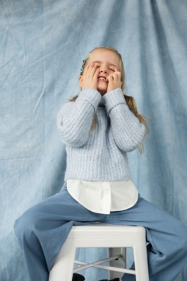 Playful children’s portrait in blue knit sweater and wide-leg pants – soft cinematic kids fashion editorial 