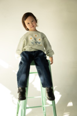 expressive children in soft pastel outfits under stage lighting — playful studio kids fashion editorial. 