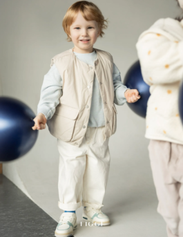 expressive children in soft pastel outfits under stage lighting — playful studio kids fashion editorial. 