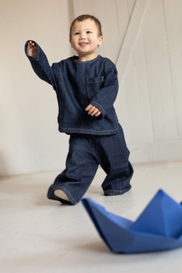 Kids fashion editorial with playful expression, clean studio colors and modern children’s styling by Berlin photographer Miriam Dang 