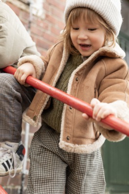 „Zwei Kinder in winterlichen Outfits vor urbaner Kulisse – Kids Fashion Editorial Outdoor“ 