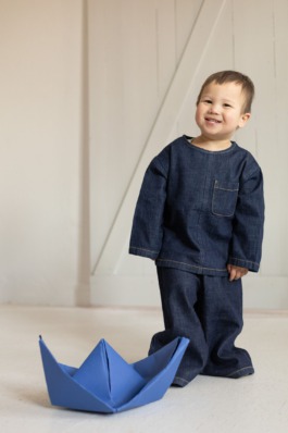 Kids fashion editorial with playful expression, clean studio colors and modern children’s styling by Berlin photographer Miriam Dang