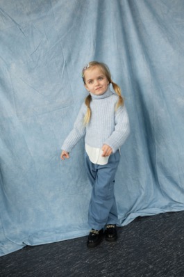 Playful children’s portrait in blue knit sweater and wide-leg pants – soft cinematic kids fashion editorial