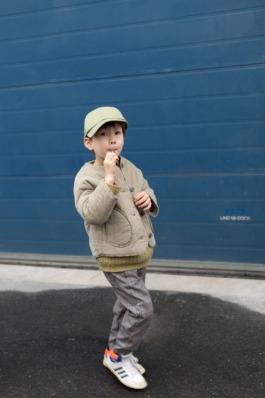„Junge mit Cap und gesteppter Jacke vor blauer Wand – Urban Kids Fashion Photography“ 