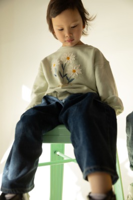 Kidswear fashion portrait in soft studio light, magazine-style cover layout — modern children’s editorial photography. 
