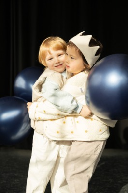 expressive children in soft pastel outfits under stage lighting — playful studio kids fashion editorial. 