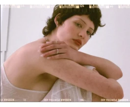 Portraitaufnahme von Model Audrey mit neutralem Gesichtsausdruck, sanftes Seitenlicht, klare Komposition. 